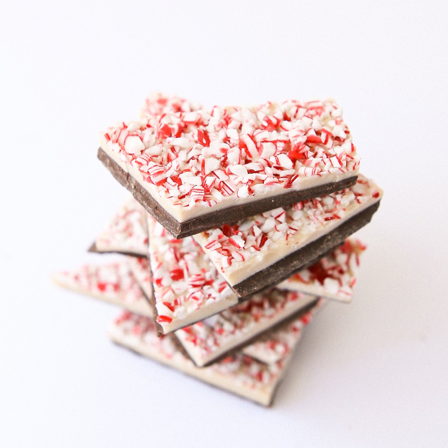 Peppermint Bark stacked neatly with several pieces against a white background