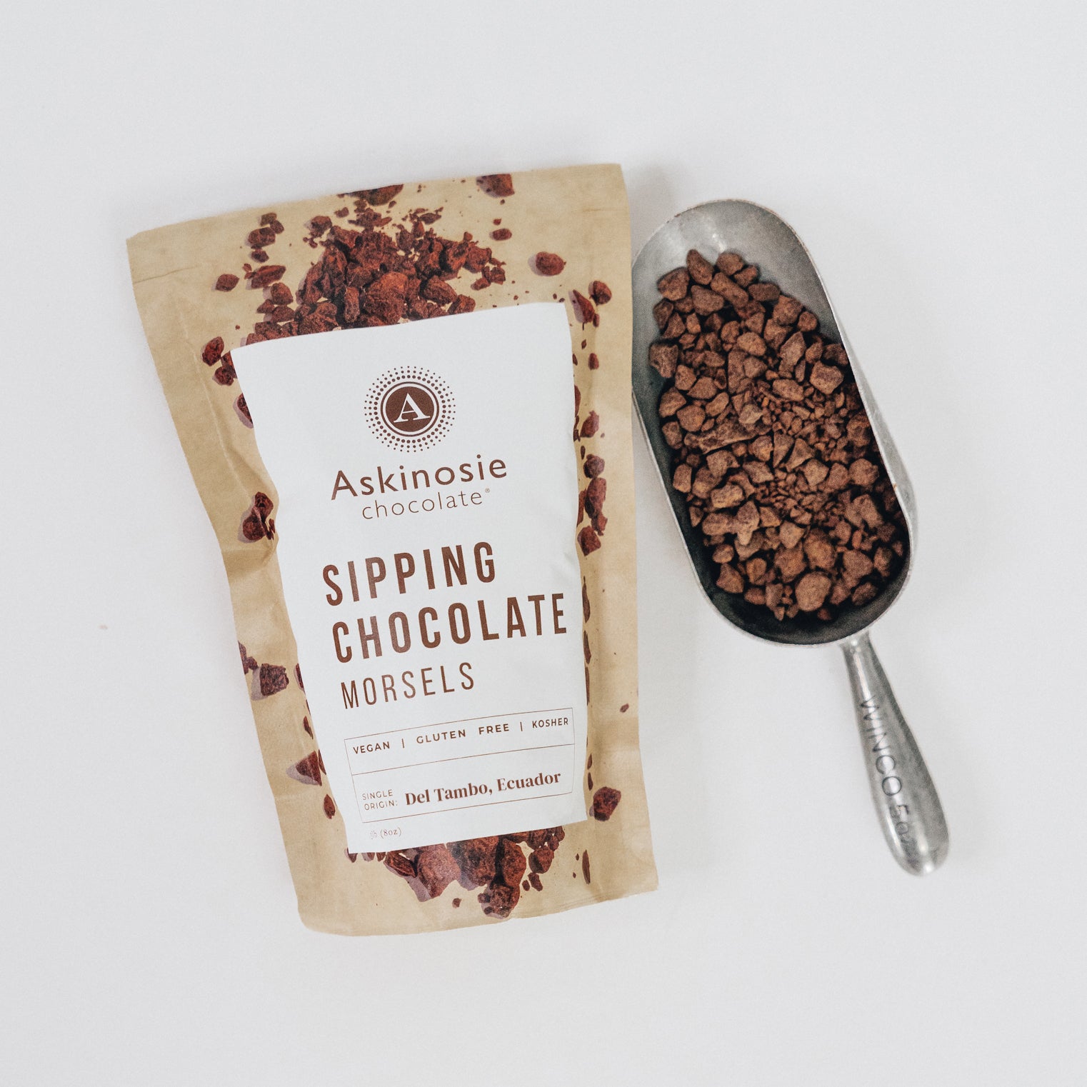 Kraft pouch filled with morsels of dark chocolate on a white background